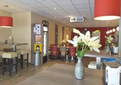 Het restaurant van Grillroom Yusuf, met rode lampen en gedekte tafels